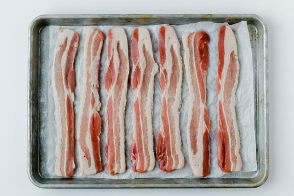 strips of bacon lined up on a silver tray