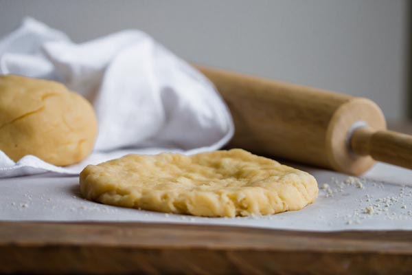 rolled out keto pizza crust on parchment paper