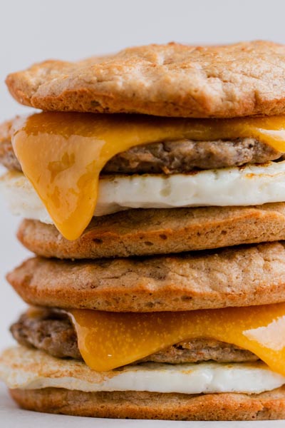 cheesy breakfast sandwich with sausage and egg in the middle of a keto biscuit