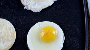 an over easy egg baking on a griddle