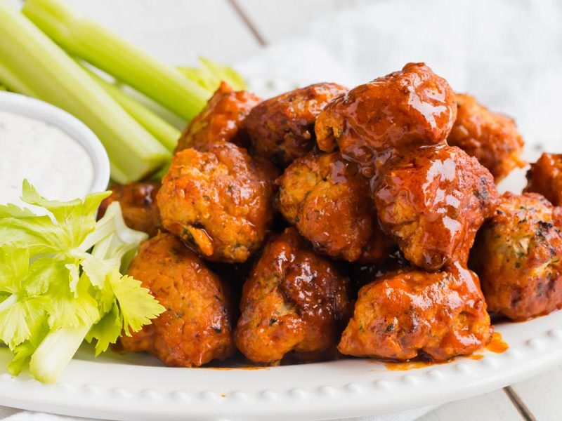 keto buffalo chicken meatballs piled on a plate with ranch sauce