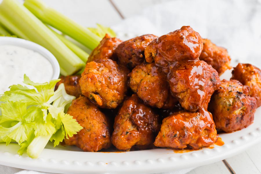 keto buffalo chicken meatballs piled on a plate with ranch sauce