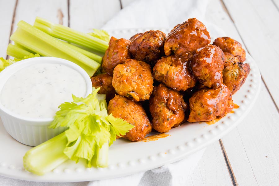 plate of buffalo chicken meatballs with celery and ranch dressing