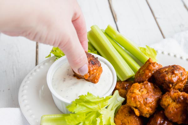 dipping a chicken keto meatball in ranch dressing