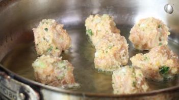 keto buffalo chicken meatballs frying in a skillet on the stove top