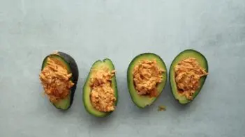 scooping out flesh of an avocado