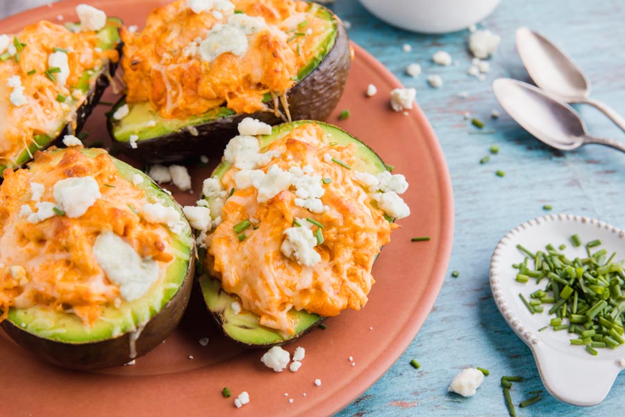 four stuffed avocados on a plate with salt