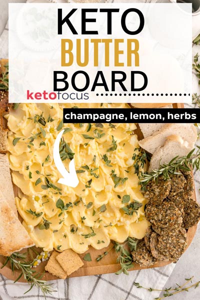 butter painted on a tray and topped with fresh herbs and garlic, surrounded by crackers and bread