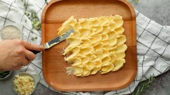 spreading butter on a wooden rounded plate with a cake spatula