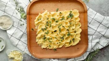 a butter board topped with fresh herbs and lemon zest