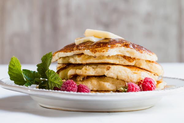 buttermilk pancakes on plate with raspberries