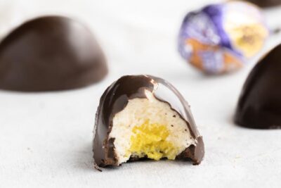 a chocolate egg with a bite taken out of the center showing the creme layers