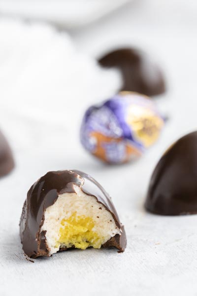 a bite taking out of a homemade cadbury egg showing the white and yellow center