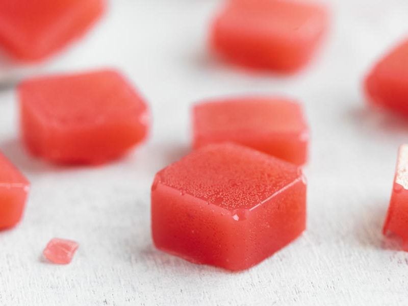 pieces of red watermelon candy on a white board