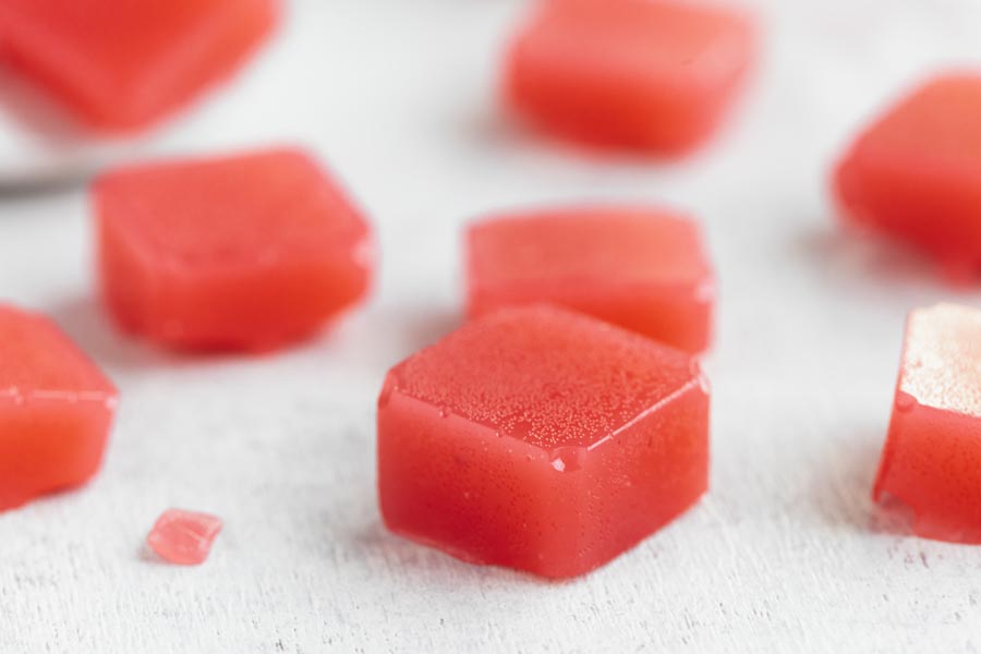 pieces of red watermelon candy on a white board