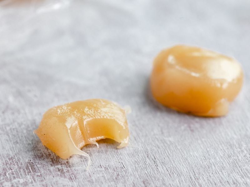 half bitten caramel next to a whole caramel chew