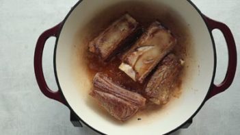 short ribs searing in an enamel cast iron dutch oven