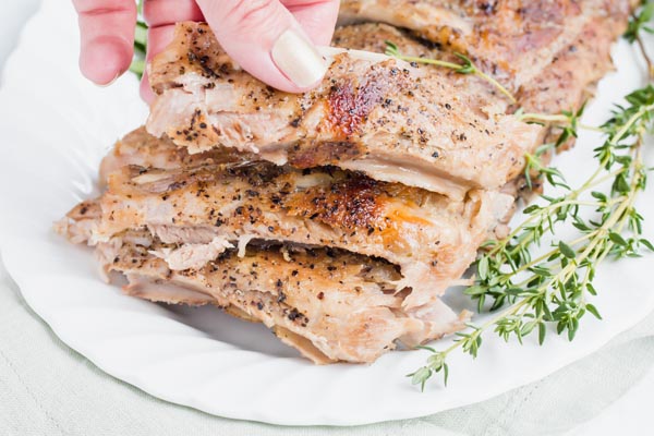 grabbing a rib from the platter of ribs