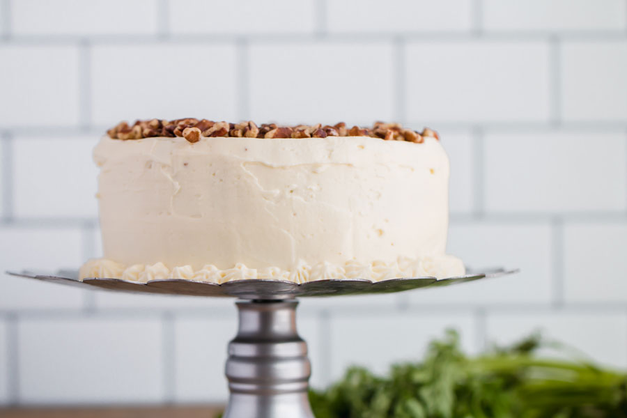 A whole keto almond flour carrot cake on a cake stand.