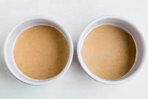 two empty cake pans lined with a parchment circle