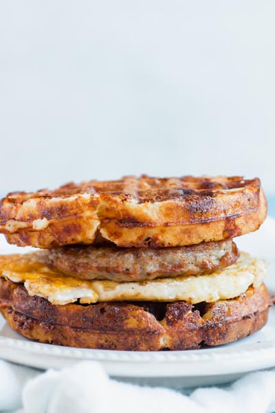a sausage and egg breakfast waffle sandwich on a plate