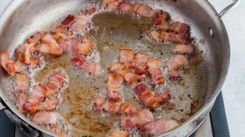 bacon slices cooking in a skillet