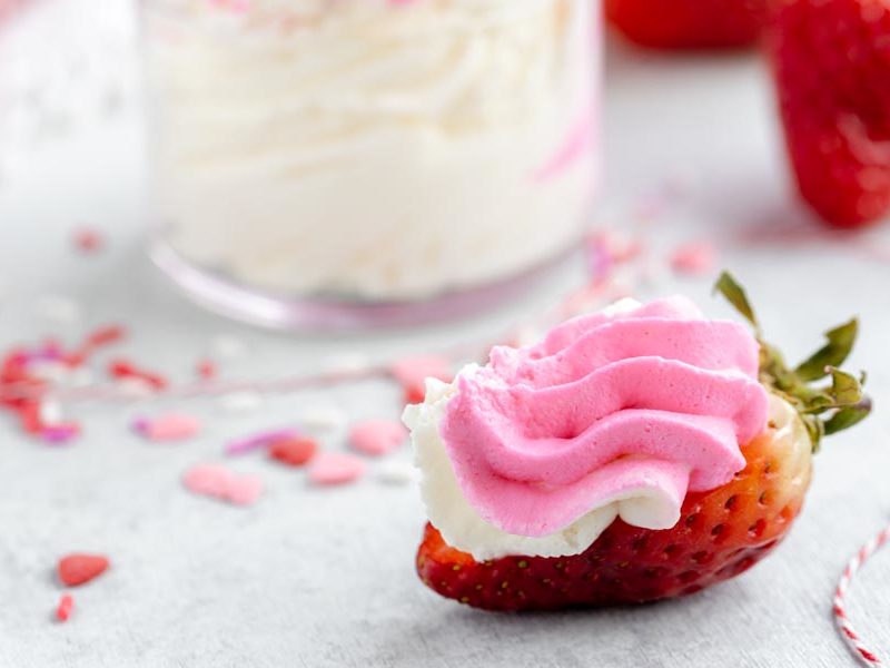pink cheesecake filling piped on a half strawberry.
