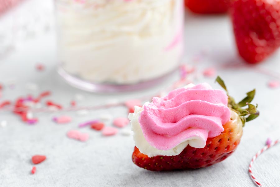 pink cheesecake filling piped on a half strawberry.