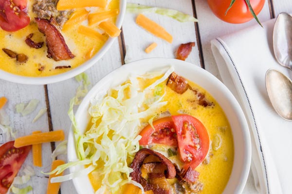 a couple bowls of cheeseburger soup with all the fixings