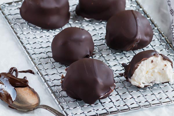 chocolate covered cheesecake bites on a wire rack