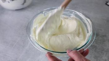 folding cheesecake mixture in a bowl with spatula