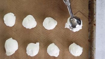 scooping cheesecake balls on a parchment lined tray
