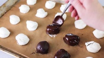 coating chocolate on a ball of cheesecake