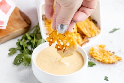dipping a waffle fry into chick-fil-a sauce