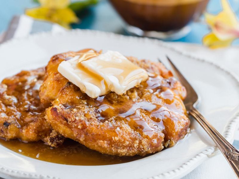 a fork sits next to chicken and waffles on a plate