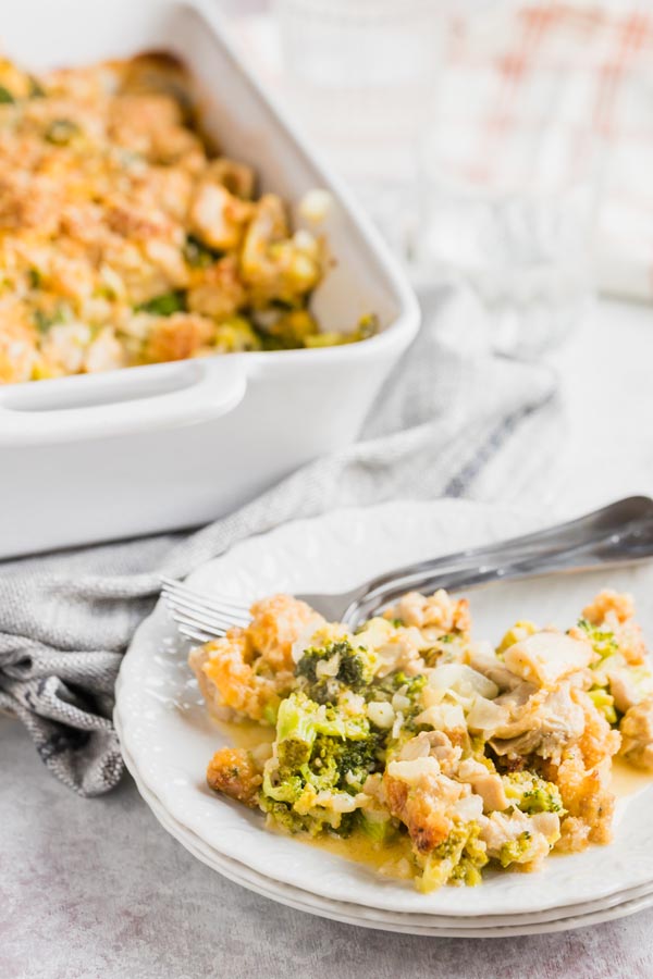 a plate with chicken casserole on it next to a whole casserole dish