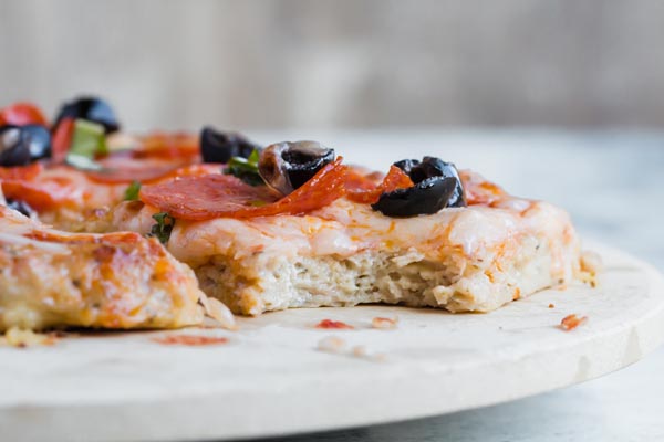 chicken pizza with a bite taken out of a slice