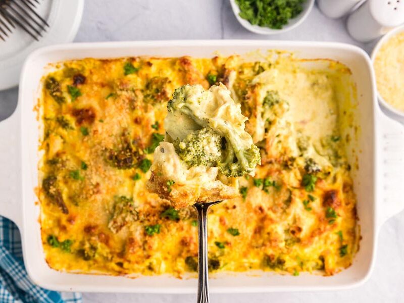 A spoon holding a serving of broccoli chicken casserole