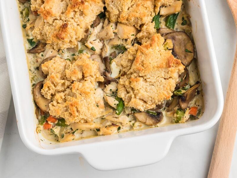 Keto biscuits dropped on top of a creamy chicken and vegetable mixture and baked in a casserole dish.