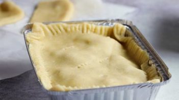 a pot pie in a freezer container with a layer of crust on top