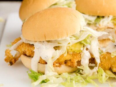 A crispy keto McChicken sandwich topped with shredded lettuce, pickles, and creamy sauce on a soft low-carb bun.