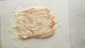 Ground chicken shaped into a large rectangular patty and coated with almond flour.