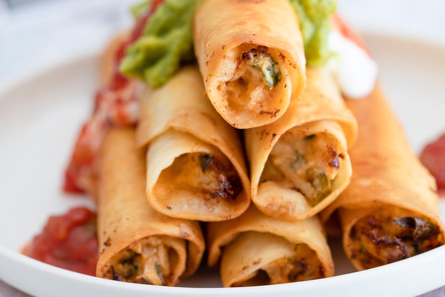 creamy filled chicken taquitos topped with salsa and sour cream