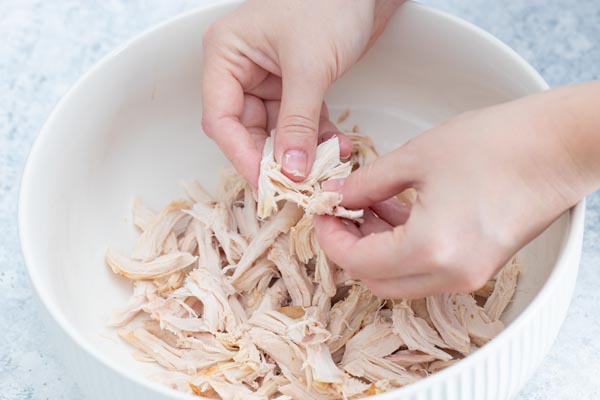 shredding chicken in a bowl