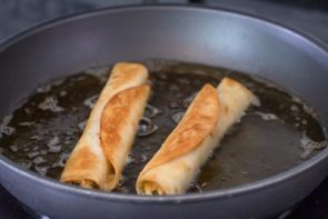 golden brown chicken taquitos cooking in a skillet