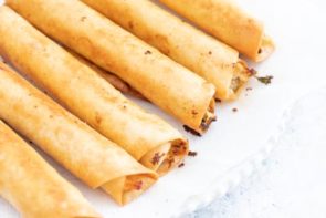 fried chicken taquitos laying down on a paper towel