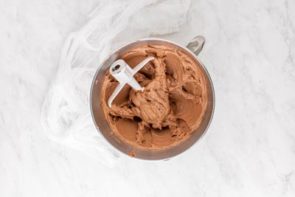 chocolate buttercream frosting sitting in a kitchen aid bowl with paddle off