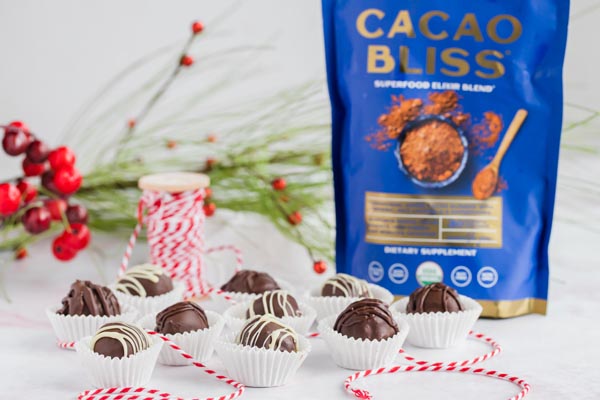 a bunch of chocolate chip cookie dough truffles with red and white rope wrapped around and a bag of cacao bliss