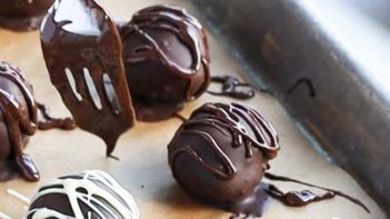 drizzling melted chocolate on top of truffles