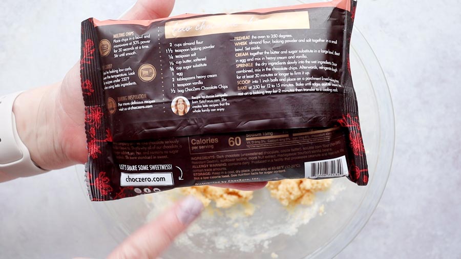 holding a bag of chocolate chips with a recipe on the back